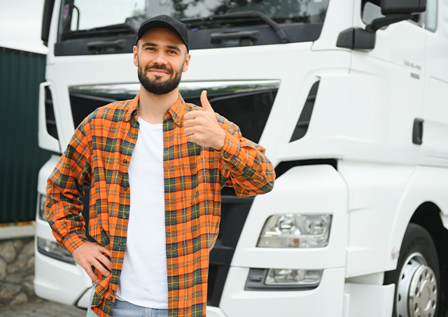 No doc low documentation truck loans with 24-hour approval for a truck driver giving a thumbs-up while standing in front of a white truck