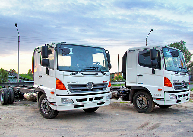 Flexible commercial vehicle financing options applied to two new white Hino cab chassis transport trucks