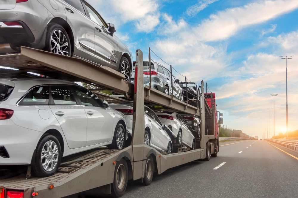 Car carrier finance options utilised to secure a multi-car transport truck fully loaded with vehicles driving on an open highway