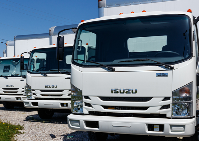 New truck loans utilised to purchase a fleet of brand new white Isuzu light commercial vehicles parked in a row