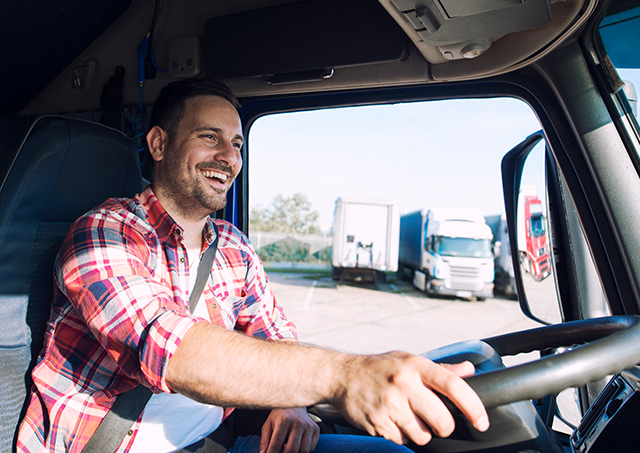 Quick truck lease options from expert brokers at your service for a professional middle-aged truck driver behind the wheel delivering cargo