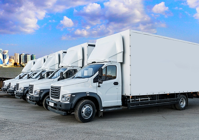 Trucks parked in a logistics warehouse parking lot, lined up for transport operations.